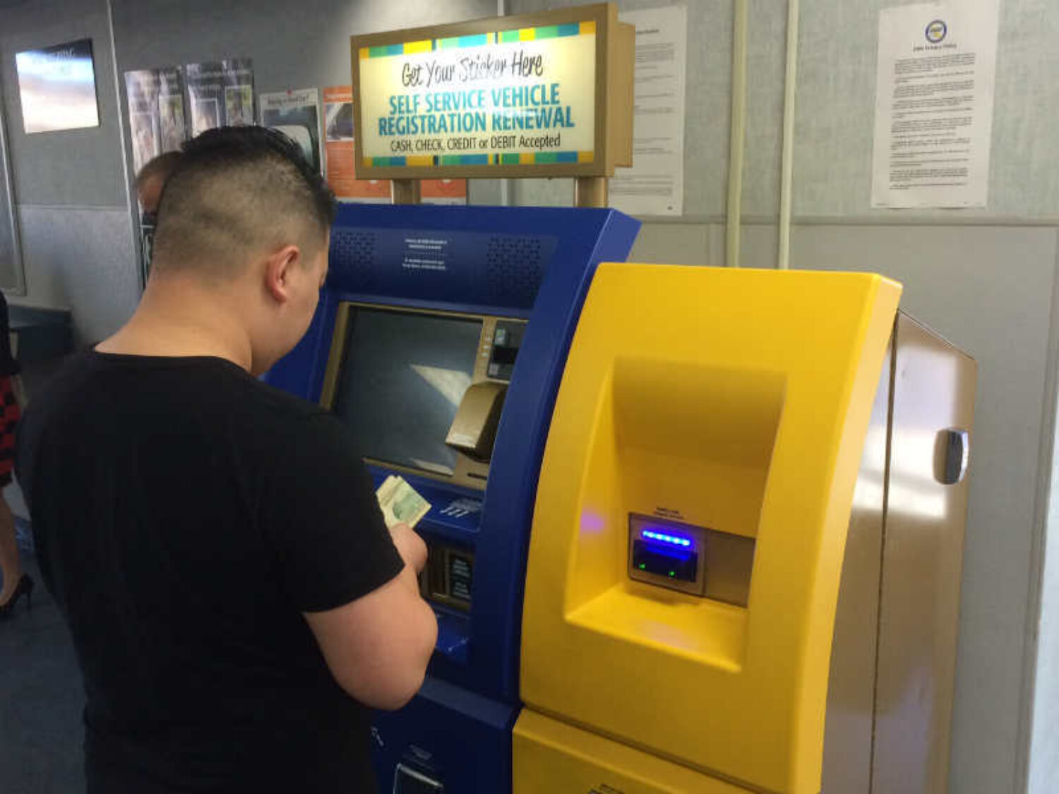 a man using a dmv self service kiosk